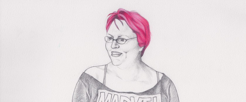 Woman with short pink hair, glasses and a Marvel shirt smiles at something to her side